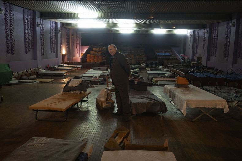 Un hombre espera a ser evacuado al oeste de Ucrania junto a una cama en un teatro que alberga a refugiados que huyen de la ofensiva rusa en la región de Donetsk, en Pavlohrad, en la zona de Dnipropetrovsk, Ucrania, el 12 de diciembre de 2024.(AP Foto/Efrem Lukatsky)