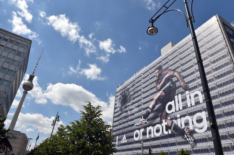 Una imagen del jugador de la selecci&oacute;n alemana, Mesut Oezil, aparece en un anuncio de adidas en un edificio en Berl&iacute;n, el viernes, 6 de junio de 2014. (AP Photo/dpa,Jens Kalaene)