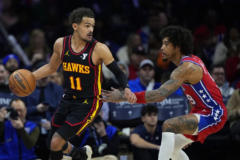 Trae Young de los Hawks de Atlanta (izquierda) intenta superar a Kelly Oubre Jr. de los 76ers de Filadelfia, durante la segunda mitad del juego de baloncesto de la NBA, el viernes 9 de febrero de 2024. (AP Foto/Matt Slocum)