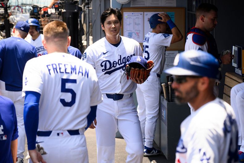 El lanzador abridor de los Dodgers de Los Ángeles, Shohei Ohtani, sonríe en el dugout durante la primera entrada de un partido de béisbol contra los Rays de Tampa Bay en Los Ángeles, el miércoles 17 de junio de 2026. (Foto AP/Kyusung Gong)