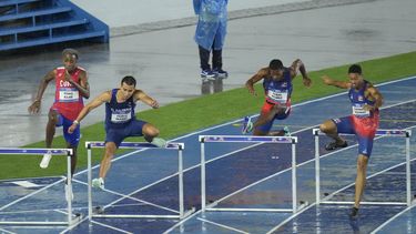 El salvadoreño Pablo Ibáñez (2do de izquierda a derecha) compite en los 400 metros con vallas el martes 4 de julio de 2023, en San Salvador (AP Foto/Arnulfo Franco)