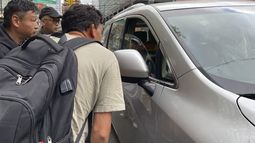 Wang Gang, de 36 años, delante, un migrante chino, habla con el conductor de un coche junto a otras personas mientras intentan conseguir un trabajo jornalero en la construcción o en otro oficio en el barrio de Flushing, en el barrio neoyorquino de Queens, el 3 de mayo de 2024. (AP Foto/Fu Ting)