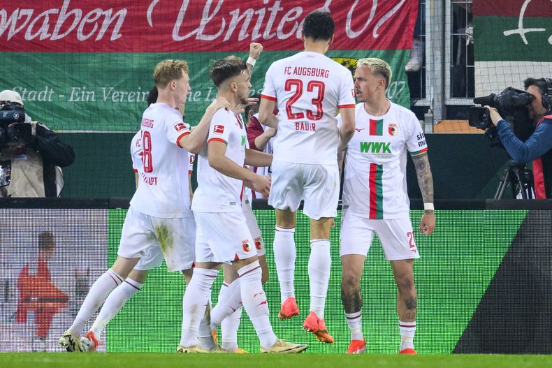 Phillip Tietz, derecha, de Augsburgo, celebra con sus compañeros de equipo después de anotar el primer gol de su equipo durante el partido de fútbol de la Bundesliga de Alemania entre Unión Berlín y Augsburgo, en la Arena WWK, en Augsburgo, Alemania, el viernes 12 de abril de 2024. (Tom Weller/dpa vía AP)
