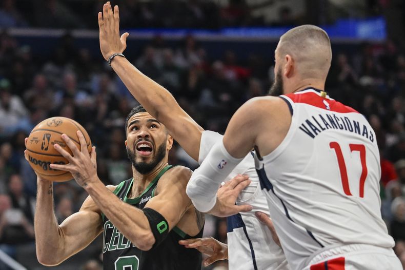 Jayson Tatum, de los Celtics de Boston, busca abrirse espacio para disparar ante Kyshawn George y Jonas Valanciunas, de los Wizards de Washington, el jueves 24 de octubre de 2024 (AP Foto/John McDonnell)