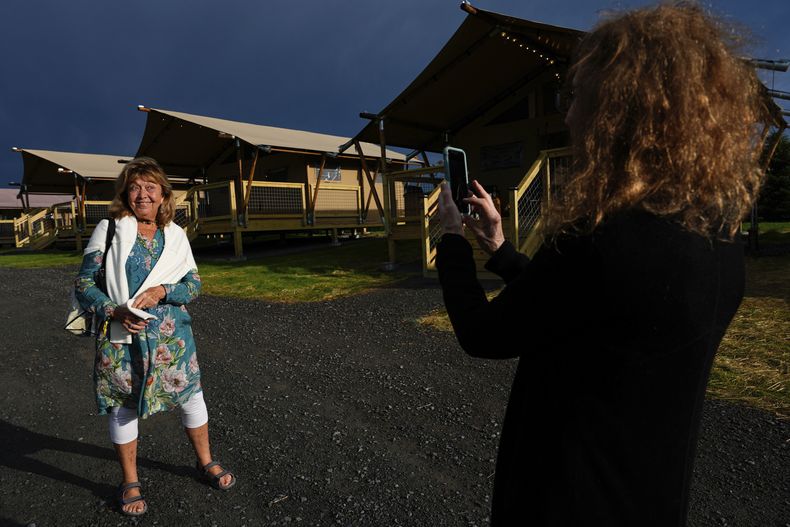 Ellen Shelburne fotografía a Beverly Cookie Grant frente a las tiendas de campaña de lujo en el Centro para las Artes Bethel Woods, sede de la Feria de Arte y Música de Woodstock, el viernes 14 de junio de 2024 en Bethel, Nueva York. (Foto AP/Julia Nikhinson)