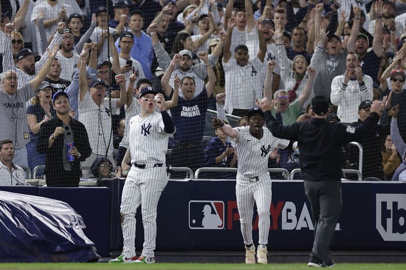 El jardinero mexicano de los Yankees de Nueva York, Alex Verdugo, y el tercera base Jazz Chisholm Jr. reacciona luego de la gran atrapada de Verdugo deslizándose para atrapar la bola en el cuarto episodio ante los Reales de Kansas City, durante el Juego 1 de la ronda de serie divisional de la Liga Americana, el sábado 5 de octubre de 2024, en Nueva York. (AP Foto/Adam Hunger)