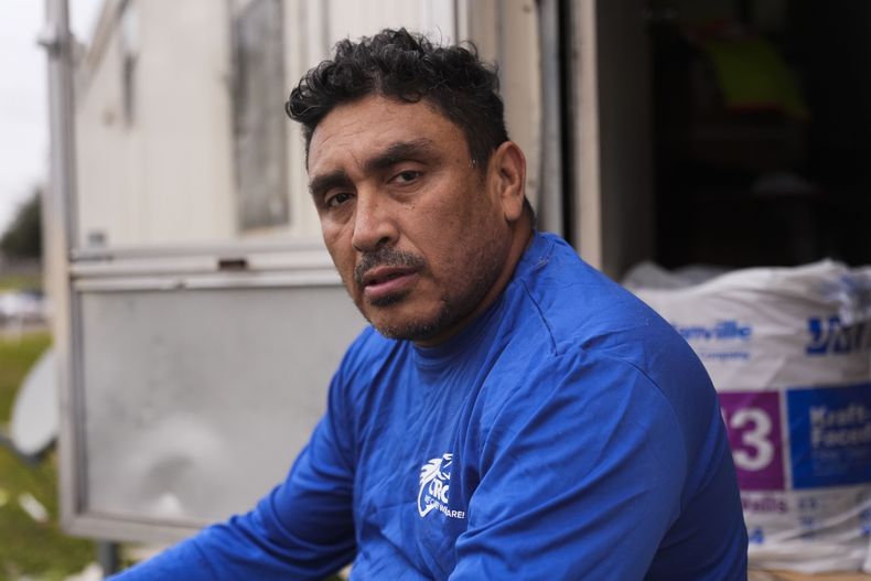 Mario Mendoza posa para una foto en un descanso mientras repara una casa móvil en Belle Chasse, Los Ángeles, el miércoles 15 de enero de 2025, que quedó afectada por el huracán Ida en 2021. (AP Foto/Gerald Herbert)