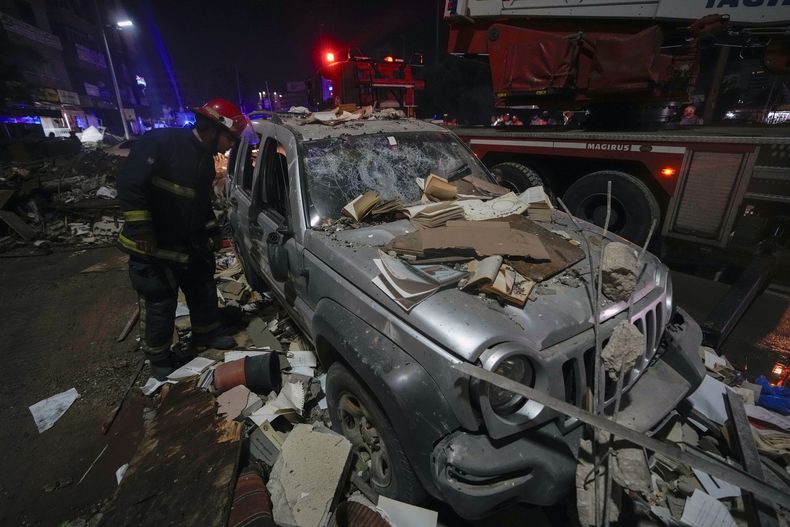 Un bombero inspecciona un auto dañado cerca de un edificio alcanzado por un ataque aéreo israelí, el lunes 30 de septiembre de 2024, en Beirut, Líbano. (AP Foto/Bilal Hussein)
