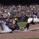Joey Wiemer (28), de los Cerveceros de Milwaukee, anota ante el intento de toque del receptor de los Gigantes de San Francisco, Blake Sabol, durante la novena entrada del juego de béisbol en San Francisco, el domingo 7 de mayo de 2023. (AP Foto/Jeff Chiu)
