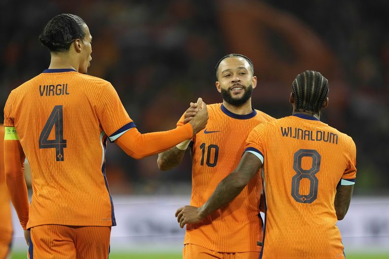 Georginio Wijnaldum (8) celebra con sus compañeros Virgil van Dijk (4) y Memphis Depay después de anotar el srgundo gol de su selección durante un partido amistoso de fútbol entre Holanda y Escocia en la Arena Johan Cruyff, en Ámsterdam, Holanda, el viernes 22 de marzo de 2024. (AP Foto/Peter Dejong)