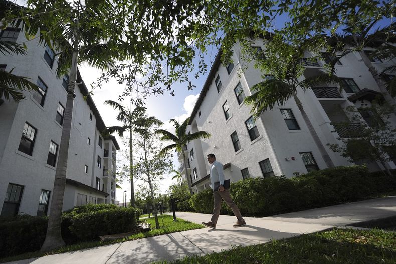 Alvaro Duran Stella, de 47 años, un venezolano con estatus de protección temporal (TPS), que estudio para convertirse en asistente legal y que ahora trabaja en Doral, Florida, camina de vuelta a su apartamento tras trabajar a distancia en el club de su urbanización, el sábado 5 de abril de 2025 en Miramar, Florida, EE.UU. (AP Foto/Rebecca Blackwell)