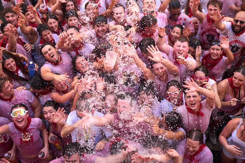 Los participantes celebran mientras el *txupinazo*, el cohete tradicional que marca el inicio de las fiestas de San Fermín, da paso a nueve días de festejos ininterrumpidos en Pamplona, España, el lunes 6 de julio de 2026. (Foto AP/Miguel Oses)