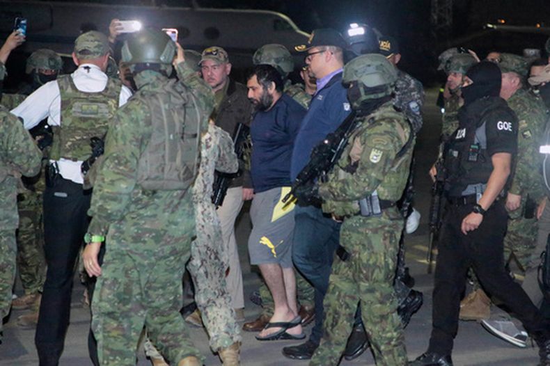 ARCHIVO - Adolfo Fito Macias, líder de la organización criminal Los Choneros, camina escoltado por policías y soldados a su llegada en Guayaquil, Ecuador, tras ser detenido, el miércoles 25 de junio de 2025. (AP Foto/Joffre Flores, Archivo)