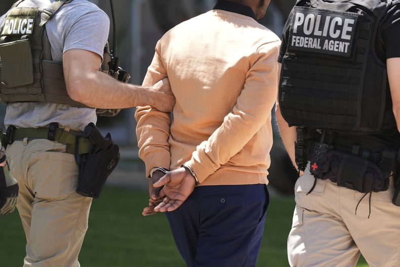 Agentes federales detienen a una persona tras una vista en una corte de inmigración, ante la corte migratoria en Phoenix, el miércoles 21 de mayo de 2025. (AP Foto/Ross D. Franklin)