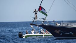 La activista climática Greta Thunberg se ve junto a una bandera palestina en el velero Madleen antes de zarpar desde Gaza junto con activistas de la Flotilla de la Libertad, tras zarpar del puerto siciliano de Catania, Italia, el domingo 1 de junio de 2025. (AP Foto/Salvatore Cavalli)