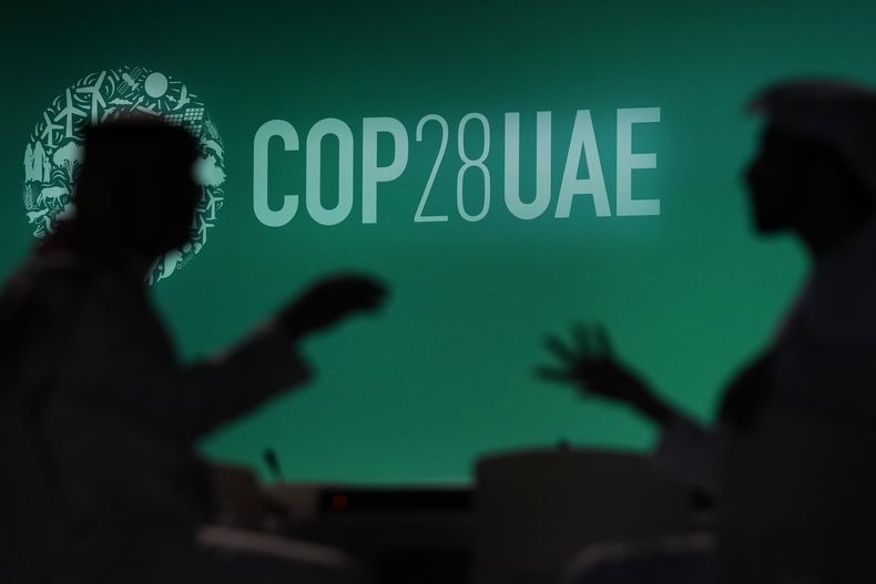 En esta imagen de archivo, la silueta de dos personas se recorta sobre el logo de la COP28, el 29 de noviembre de 2023, en Dubái, Emiratos Árabes Unidos. (AP Foto/Rafiq Maqbool, archivo)