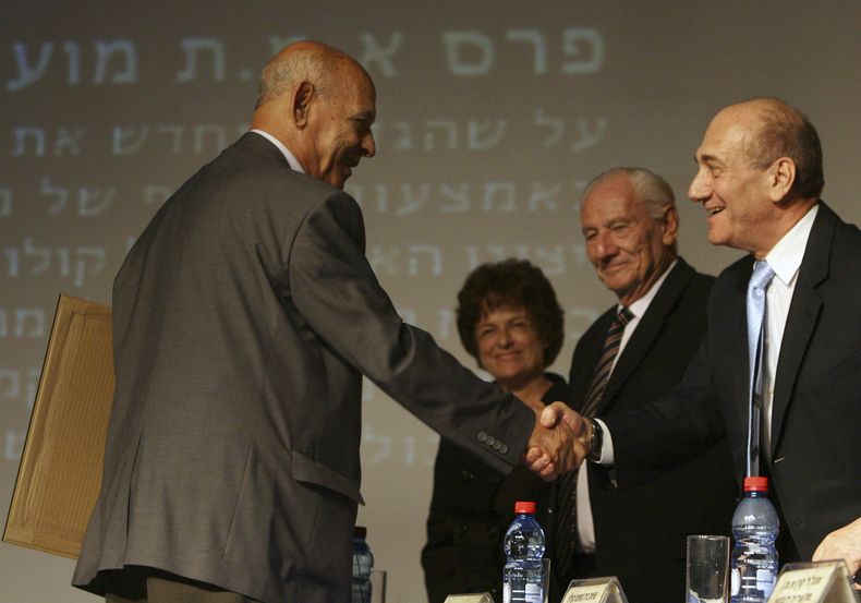 ARCHIVO - El autor israelí nacido en Irak Sami Michael, izquierda, es felicitado por el primer ministro israelí Ehud Olmert, derecha, mientras recibe el Premio Emet en Jerusalén el miércoles, 7 de noviembre de 2007. Michael, un galardonado autor iraquí-israelí que fue conocido por escribir conmovedoramente sobre las minorías oprimidas y los desafíos que enfrentan los judíos de los países árabes, ha fallecido. Tenía 97 años. (Foto AP/Jim Hollander, Pool, archivo)