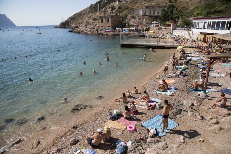 ARCHIVO - Gente pasa un día de playa en la bahía de Balaklava, península de Crimea, 9 de agosto de 2015. La península de Crimea ha sido un patio de juegos y un campo de batalla durante siglos. (AP Foto, File)