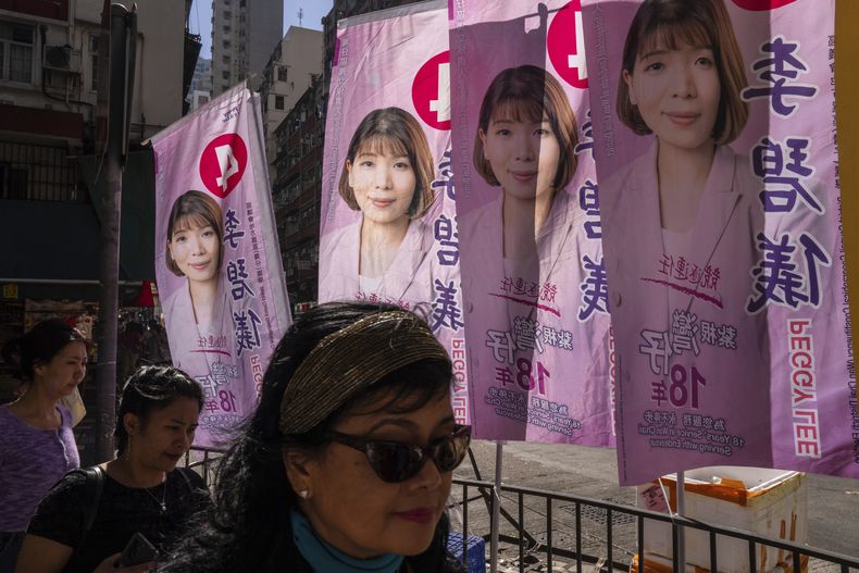Peatones pasan junto a carteles que promocionan candidatos durante las elecciones del consejo de distrito en Hong Kong, el domingo 10 de diciembre de 2023. (Foto AP/Louise Delmotte)