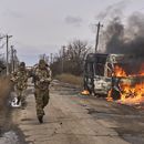 En esta foto distribuida por la 10ma Brigada de Montaña Edelweiss, de Ucrania, soldados ucranianos pasan junto a un bus impactado por un dron ruso cerca de Bajmut, región de Donetsk, Ucrania, 23 de noviembre de 2023. (Shandyba Mykyta, 10ma Brigada de Montaña Edelweiss, via AP)