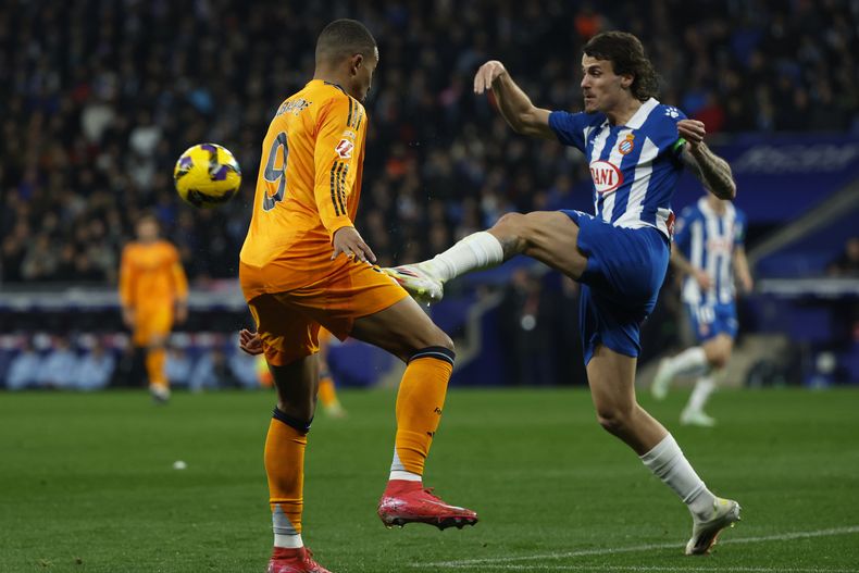 Carlos Romero (derecha) del Espanyol pugna por el balón con Kylian Mbappé del Real Madrid en el partido de la Liga española, el sábado 1 de febrero de 2025. (AP Foto/Joan Monfort)
