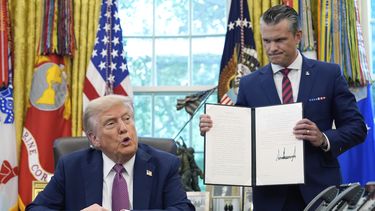 El presidente de EEUU, Donald Trump, habla mientras el secretario de Defensa, Pete Hegseth, sostiene una orden ejecutiva firmada en el Despacho Oval de la Casa Blanca, en Washington, el viernes 5 de septiembre de 2025. (AP Foto/Alex Brandon)