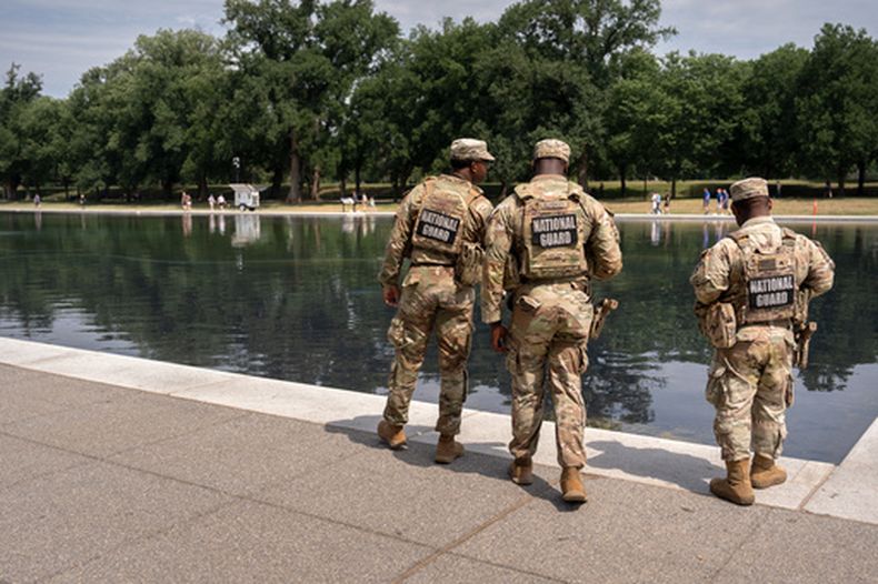 Miembros de la Guardia Nacional observan el estanque reflectante del Monumento a Lincoln, el lunes 22 de junio de 2026, en Washington. (Foto AP/Mark Schiefelbein)