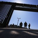 Agentes de la Patrulla Fronteriza y efectivos militares se detienen dentro de una puerta en uno de los dos muros fronterizos que separan México de Estados Unidos durante una conferencia de prensa sobre las operaciones conjuntas en las que participan militares y la Patrulla Fronteriza, el viernes 21 de marzo de 2025, en San Diego. (AP foto/Gregory Bull)