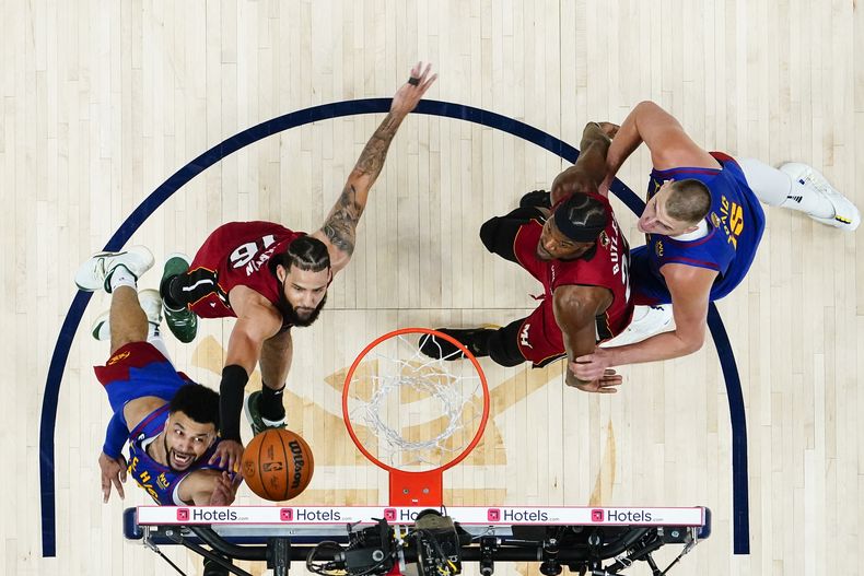 Jamal Murray, base de los Nuggets de DEnver, dispara frente a Caleb Martin, del Heat de Miami, en el primer partido de las Finales de la NBA, el jueves 1 de junio de 2023 (AP Foto/Jack Dempsey, Pool)