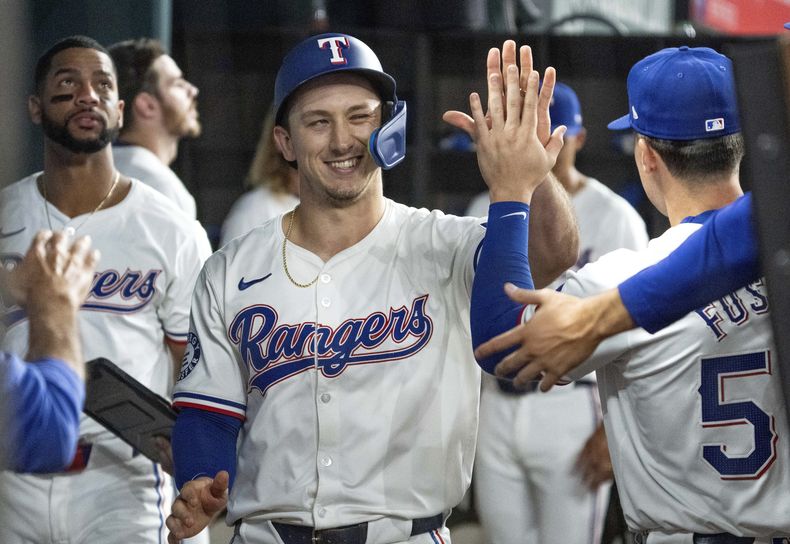 Wyatt Langford de los Rangers de Texas es felicitado en el dugout por Justin Foscue tras anotar en un sencillo de Nathaniel Loew en la cuarta entrada ante los Yankees de Nueva York el miércoles 4 de septiembre del 2024. (AP Foto/Jeffrey McWhorter)