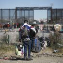 Migrantes carga varias mochilas mientras se dirige hacia la barrera en entrada de la frontera con Estados Unidos desde Ciudad Juárez, México, el 27 de diciembre de 2023. (AP Foto/Christian Chávez)