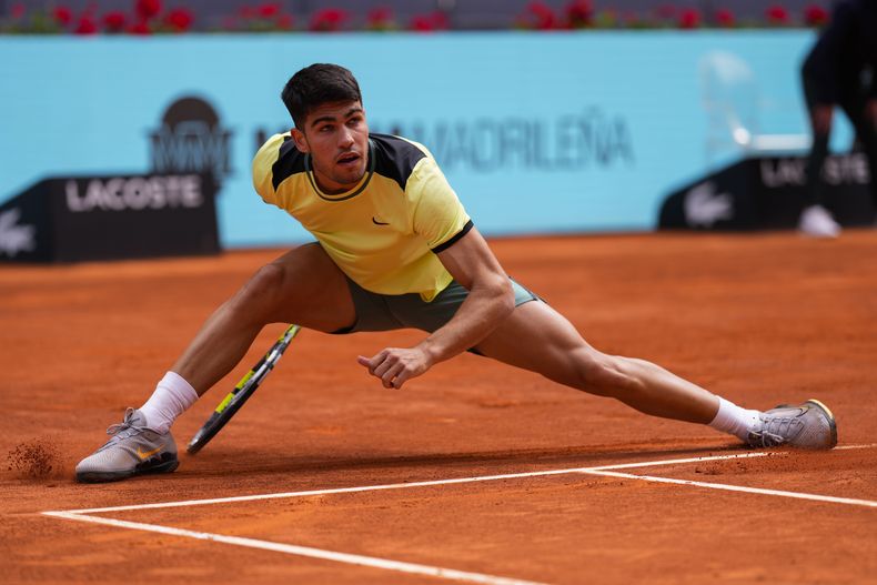 Carlos Alcaraz se estira durante el partido contra Alexander Shevchenko en el Abierto de Madrid, el viernes 26 de abril de 2024. (AP Foto/Manu Fernández)