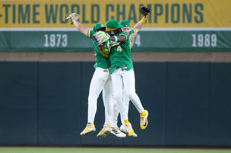 Tyler Soderstrom, izquierda, Lawrence Butler (4) y Henry Bolte, de los Atléticos, celebran la victoria sobre los Piratas de Pittsburgh en el juego de béisbol de Grandes Ligas, el lunes 15 de junio de 2026, en West Sacramento, California. (AP Foto/Scott Marshall)