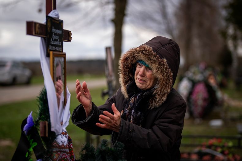 Valentyna Nechyporenko, de 77 años, llora en la tumba de su hijo Ruslan, de 47, durante su funeral en el cementerio de Bucha, en las afueras de Kiev, el lunes 18 de abril de 2022. Ruslan fue asesinado por el ejército ruso el 17 de marzo mientras entregaba ayuda humanitaria a sus vecinos en las calles de Bucha. (Foto AP/Emilio Morenatti)