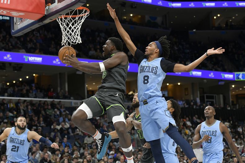 El armador de los Timberwolves de Minnesota Anthony Edwards (5) tira ante el alero de los Grizzlies de Memphis Ziaire Williams (8) en la 1ra mitad del juego de la NBA el domingo 26 de noviembre de 2023, en Memphis, Tennessee. (AP Foto/Brandon Dill)