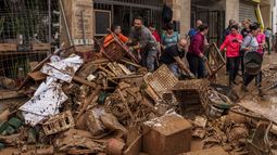 Varias personas retiran el barro de una tienda afectada por las inundaciones en Chiva, España, el 1 de noviembre de 2024. (AP Photo/Manu Fernández)