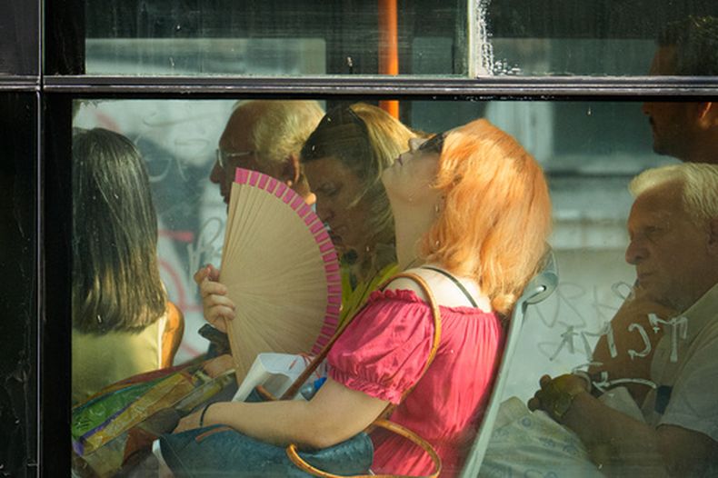 Personas tratan de protegerse del calor en un autobús en Bucarest, Rumania, el 6 de agosto del 2026. (AP foto/Vadim Ghirda)
