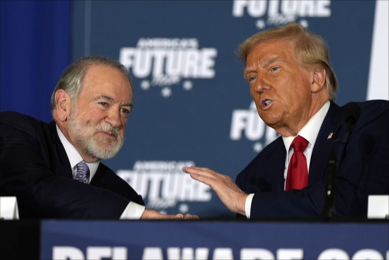 El candidato presidencial republicano y expresidente, Donald Trump, habla con el exgobernador de Arkansas, Mike Huckabee, en una mesa redonda en el Drexelbrook Catering & Event Center, el martes 29 de octubre de 2024, en Drexel Hill, Pensilvania. (AP Foto/Julia Demaree Nikhinson)