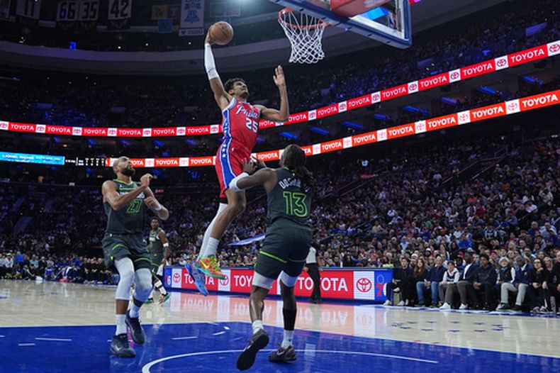 Dominik Barlow, de los 76ers de Filadelfia, realiza una clavada frente al francés Rudy Gobert, de los Timberwolves de Minnesota, el viernes 3 de abril de 2026 (AP Foto/Matt Rourke)