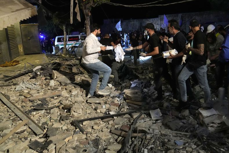 Varias personas trabajan en la recuperación de los restos de las víctimas de un ataque aéreo israelí que alcanzó un edificio de apartamentos en Beirut, Líbano, el 3 de octubre de 2024. (AP Foto/Hussein Malla)
