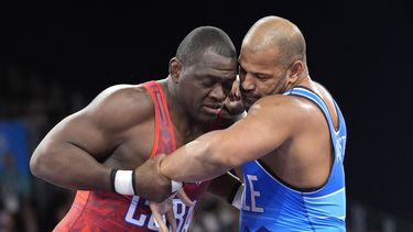 El cubano Mijaín López y el chileno Yasmani Acosta (derecha) compiten en la final de los 130 kilogramos de la lucha grecorromana de los Juegos Olímpicos de París, el martes 6 de agosto de 2024. (AP Foto/Eugene Hoshiko)