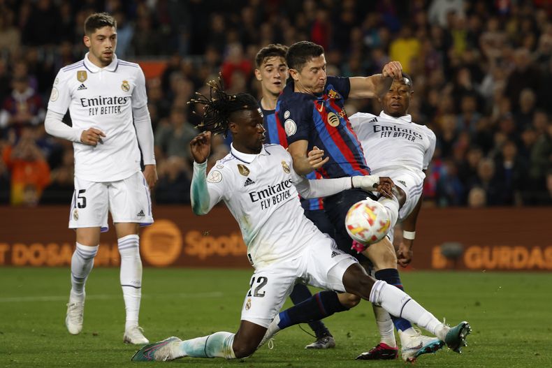 ARCHIVO - Robert Lewandowski (centro) del Barcelona pugna el balón con Eduardo Camavinga (izquierda) y David Alaba del Real Madrid durante el partido de la Liga española, el miércoles 5 de abril de 2023. (AP Foto/Joan Monfort)