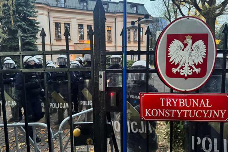 En esta imagen tomada con un celular, agentes de policía custodian la entrada al Tribunal Constitucional de Polonia en la capital del país, Varsovia, el 31 de octubre de 2026. (AP Foto/Rafal Niedzielski)