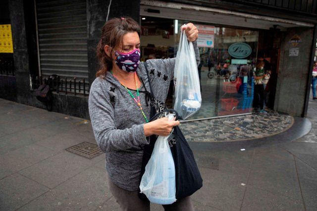 Una mujer muestra las compras que hizo en un supermercado, el 14 de abril de 2021, en Caracas (Venezuela). EFE/RAYNER PEÑA R.
