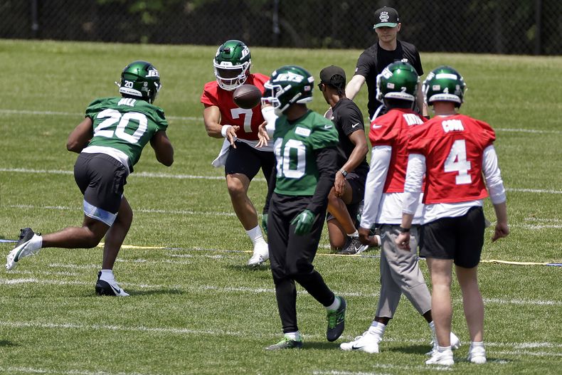 Justin Fields (7), quarterback de los Jets de Nueva York, pasa el balón a Breece Hall (20) durante un entrenamiento del equipo de la NFL, el martes 3 de junio de 2025, en Florham Park, N.J. (AP Foto/Adam Hunger)