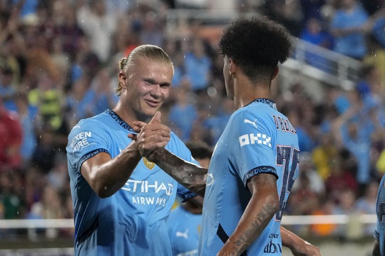 El mediocampista del Manchester City Nico OReilly celebra su gol en el duelo amistoso ante el Barcelona con Erling Haaland el martes 30 de julio del 2024. (AP Foto/John Raoux)