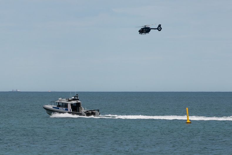 Un barco y un helicóptero de la policía patrullan una zona de la playa de Sorrento, en Perth, Australia, el 18 de septiembre de 2026, tras un presunto ataque mortal de tiburón. (Andrew OConnor/Australian Broadcasting Corp via AP)