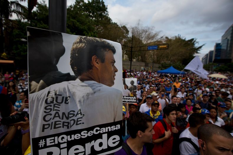 Manifestantes alzan en primer plano un poster con el retrato del l&iacute;der opositor Leopoldo L&oacute;pez cuya libertad est&aacute;n demandando en una nueva protesta en Caracas, Venezuela, el viernes 4 de abril de 2014. (AP Photo/Fernando Llano)
