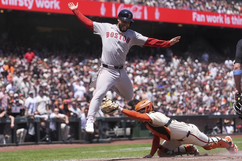 Abraham Toro, izquierda, de los Medias Rojas de Boston, es puesto fuera por el receptor de los Gigantes de San Francisco, Patrick Bailey, durante la cuarta entrada del juego de béisbol de Grandes Ligas, el domingo 22 de junio de 2025, en San Francisco. (AP Foto/Jeff Chiu)