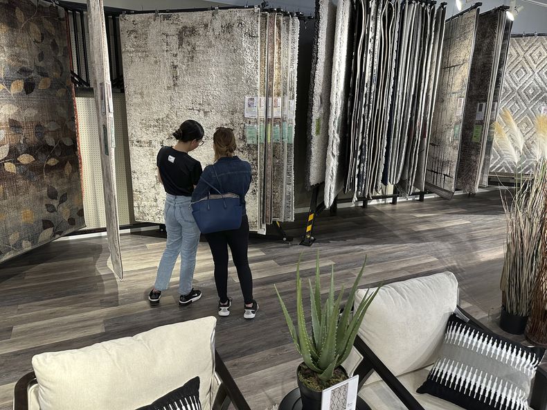 Clientes miran muestras de alfombras en exhibición en una tienda de mobiliario, el sábado 2 de junio de 2024, en Lone Tree, Colorado. (AP Foto/David Zalubowski)